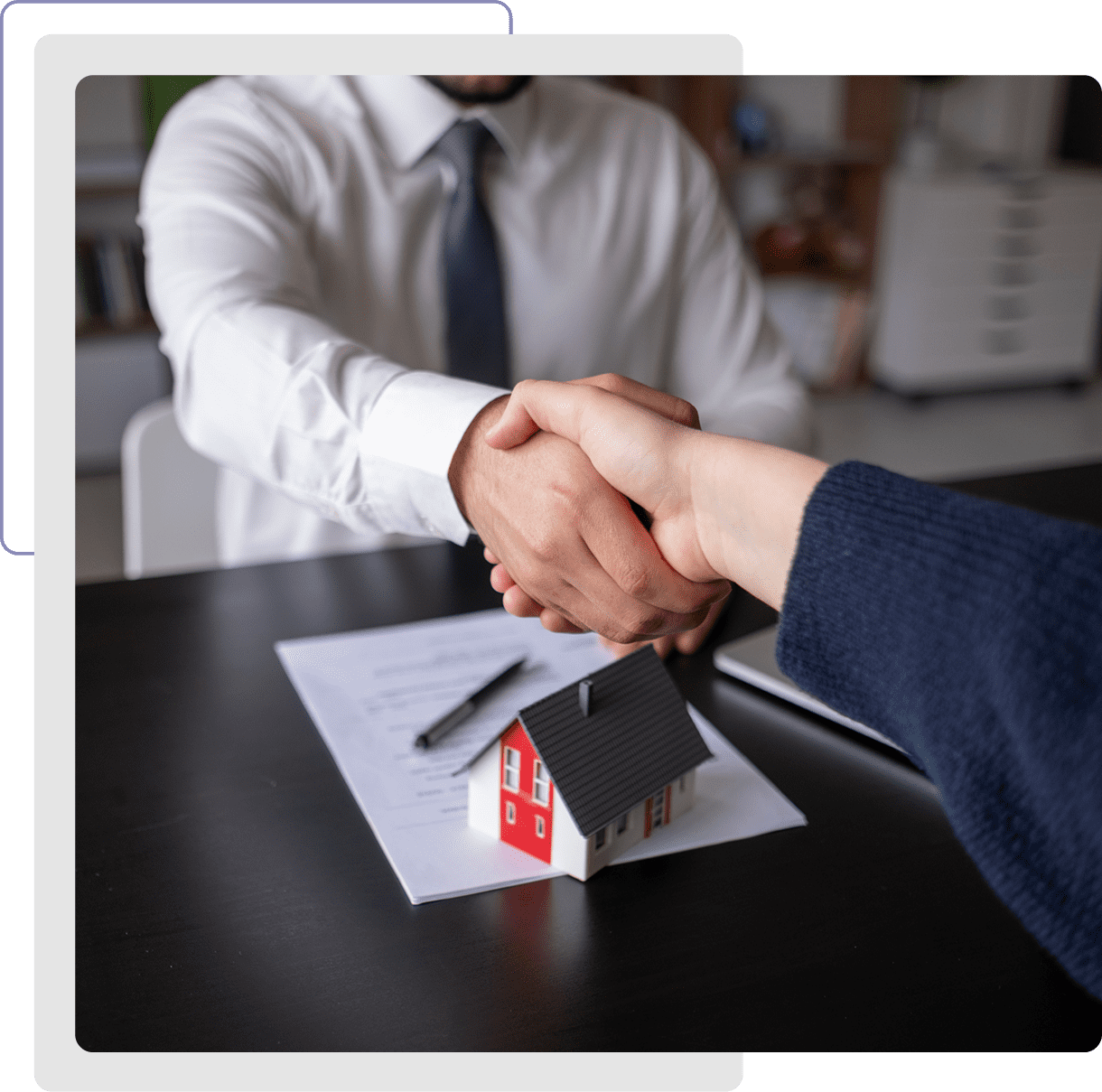 Handshake over house contract and model.